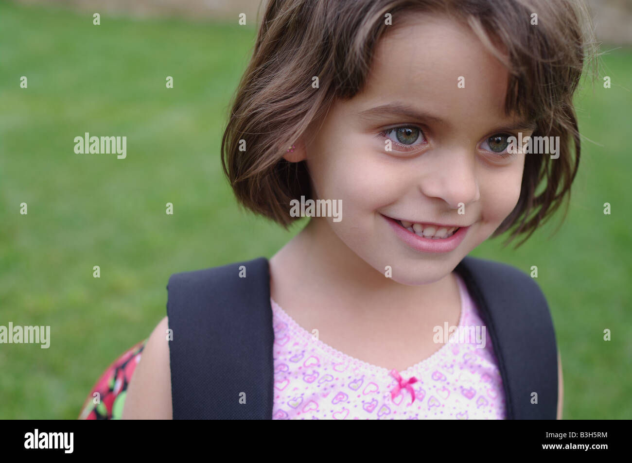 Smiling 5 years old girl with backpack waiting for the start of