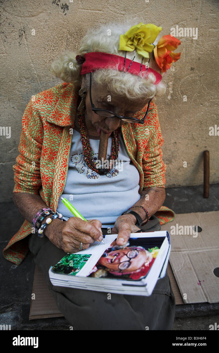 The local lady who appeared on the inside of a Lonely Planet Cuba signs a copy for a tourist in Havana in Cuba. Stock Photo