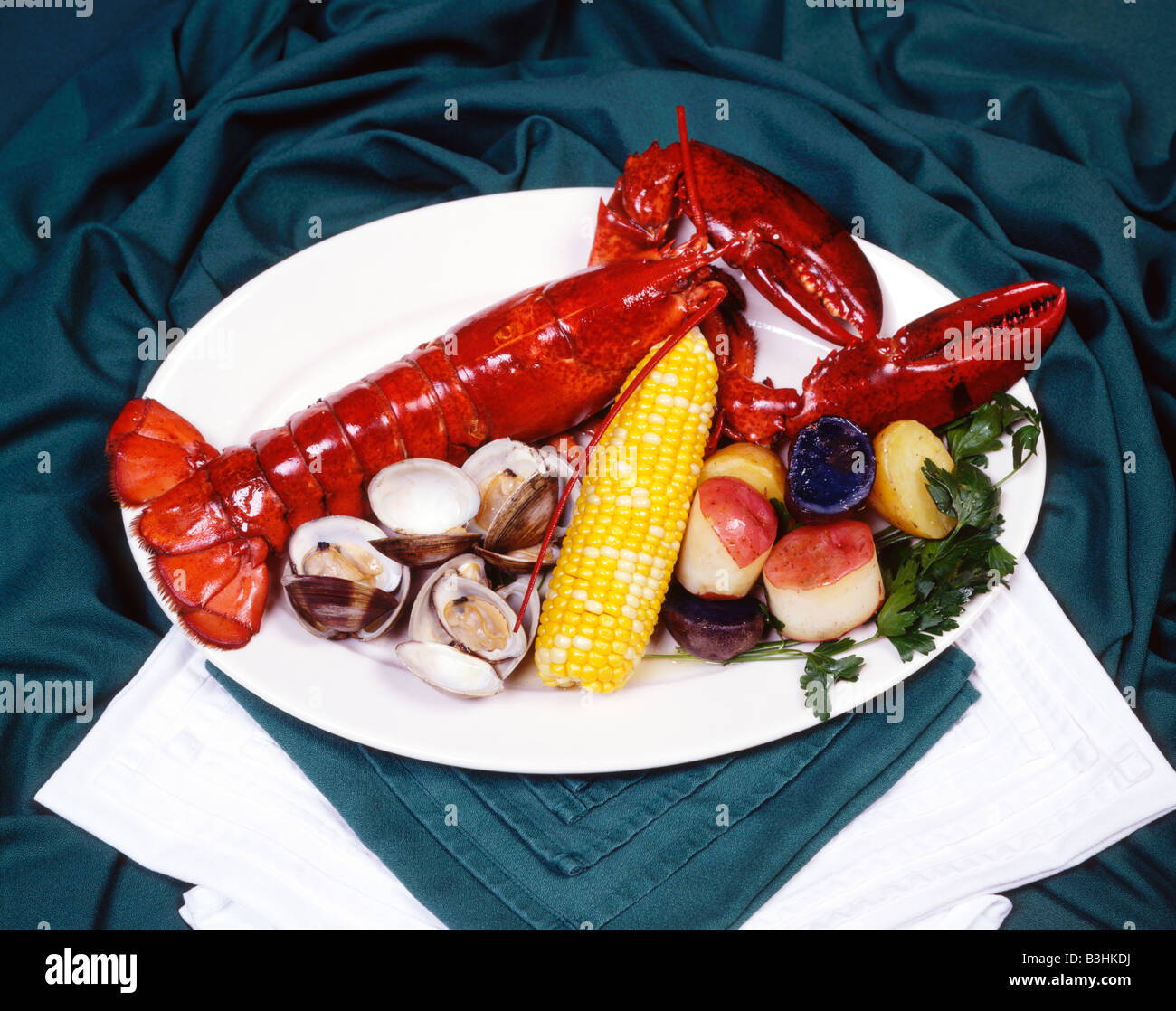 Lobster and Clam with corn on the cob and potatoes dinner plate entree Stock Photo