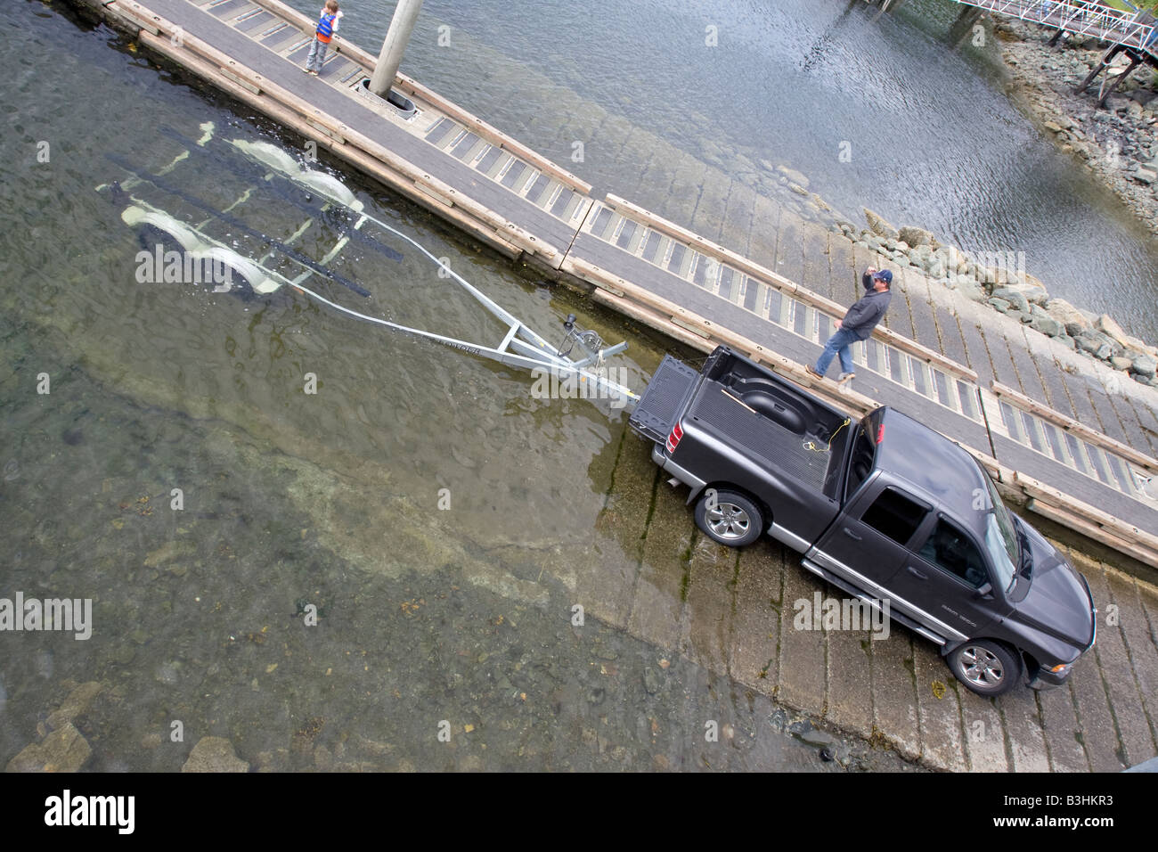 Van and trailer retrieving small boat from the small boat harbour in