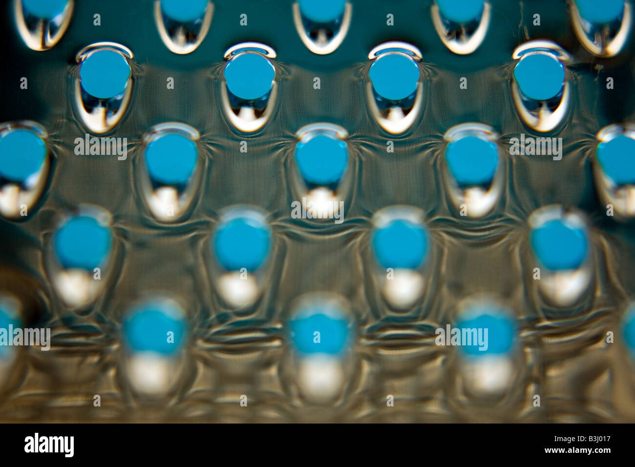 https://c8.alamy.com/comp/B3J017/abstract-close-up-of-a-cheese-grater-with-blue-backlighting-B3J017.jpg