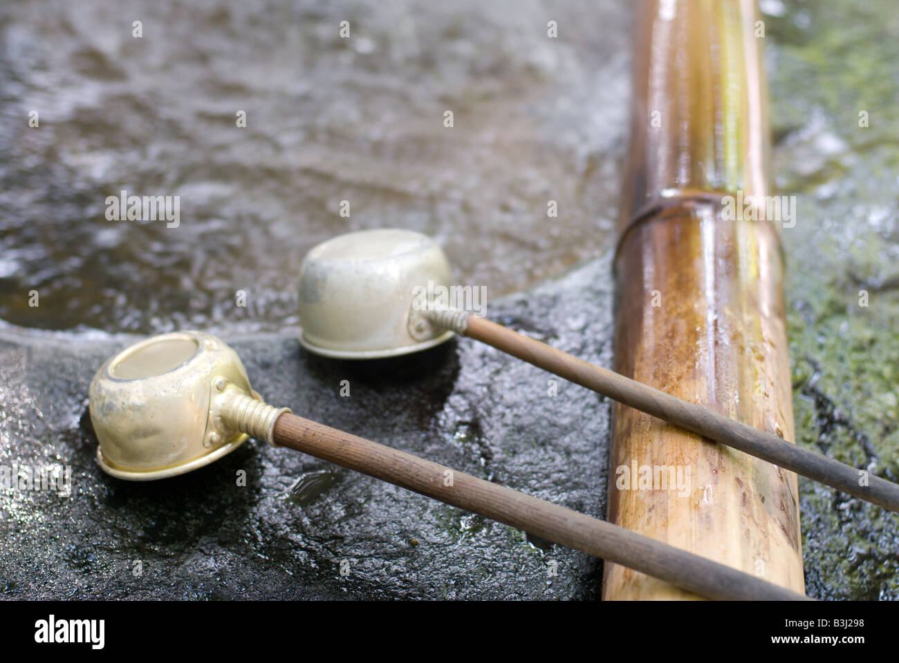 Two scoops on a bamboo rest at a steaming hot-springs chozuya for ritual cleansing before entering a Shinto Shrine Stock Photo