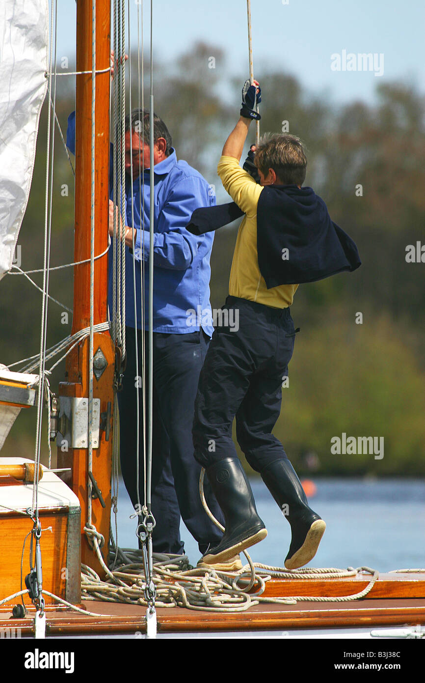 Hoisting the mainsail on a Broads cruiser Stock Photo Alamy