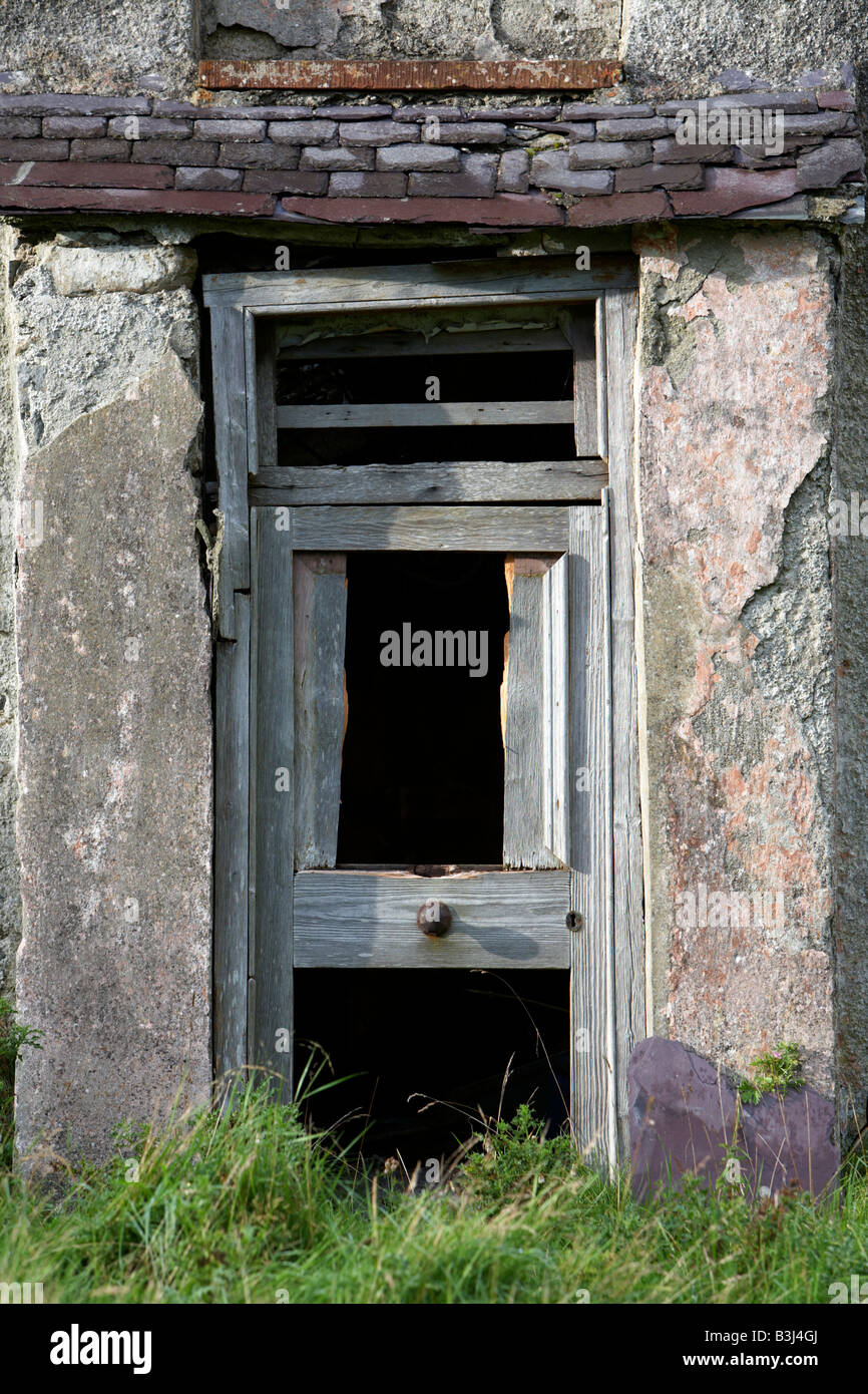 broken wooden door entrance to abandoned ruined old irish farmhouse