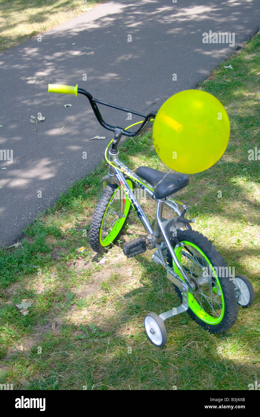 Green balloon tied to child's bike with training wheels. Dragon Festival  Lake Phalen Park St Paul Minnesota USA Stock Photo - Alamy