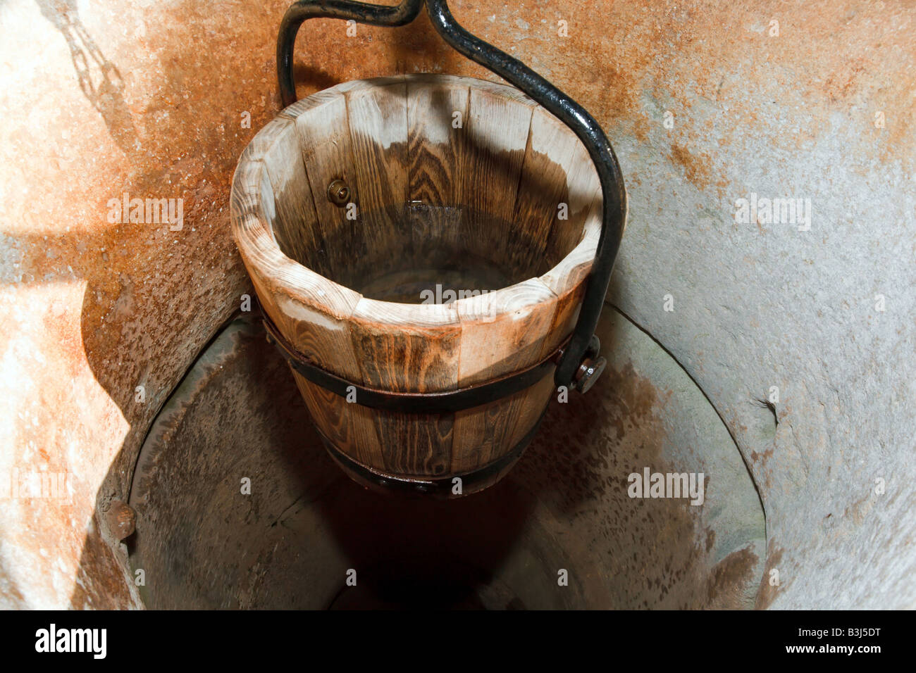 traditional wooden bucket in old stone well Stock Photo