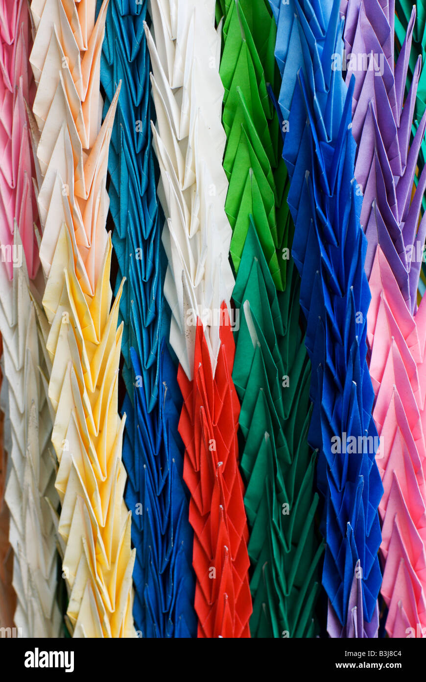Long chains of colourful paper cranes making a thousand cranes is said to make a wish come true hung as prayers at a Shrine. Stock Photo