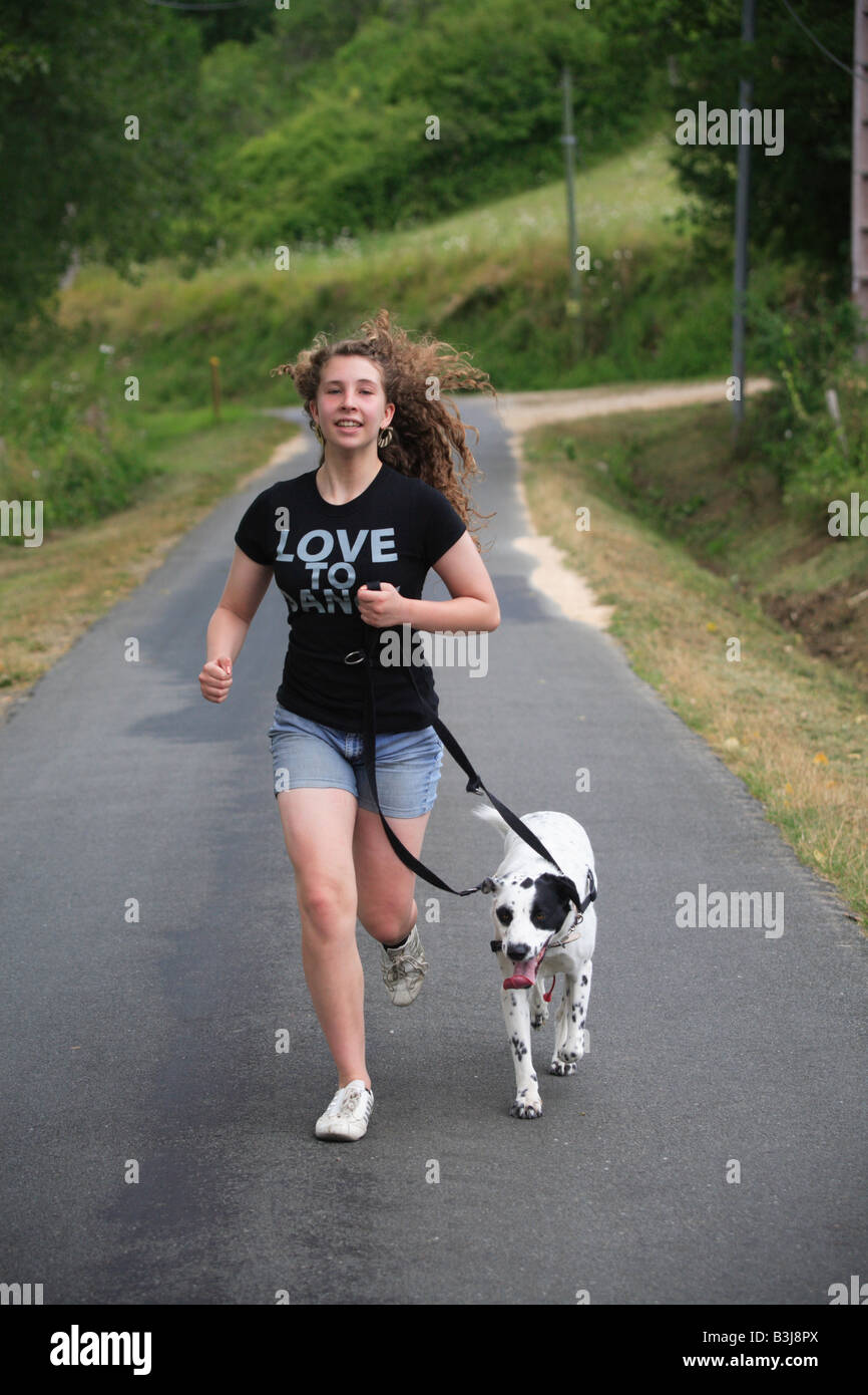 girl running pet black white spotty dog exercise Stock Photo