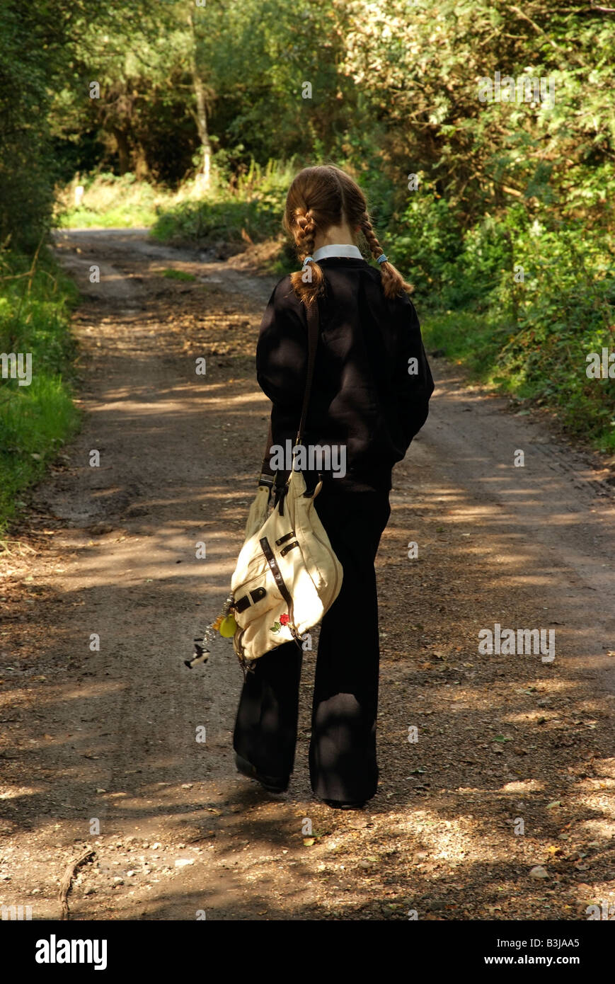 Young girl walking alone on a country lane Stock Photo - Alamy
