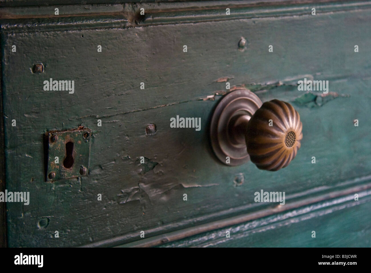 door wood dark blue-green handle knob brass lock cavity open close entry key metal Stock Photo