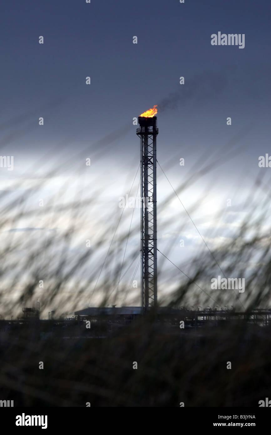 Tower flare stack of St Fergus gas terminal near Fraserburgh, Scotland, UK, seen from the beach at dusk Stock Photo