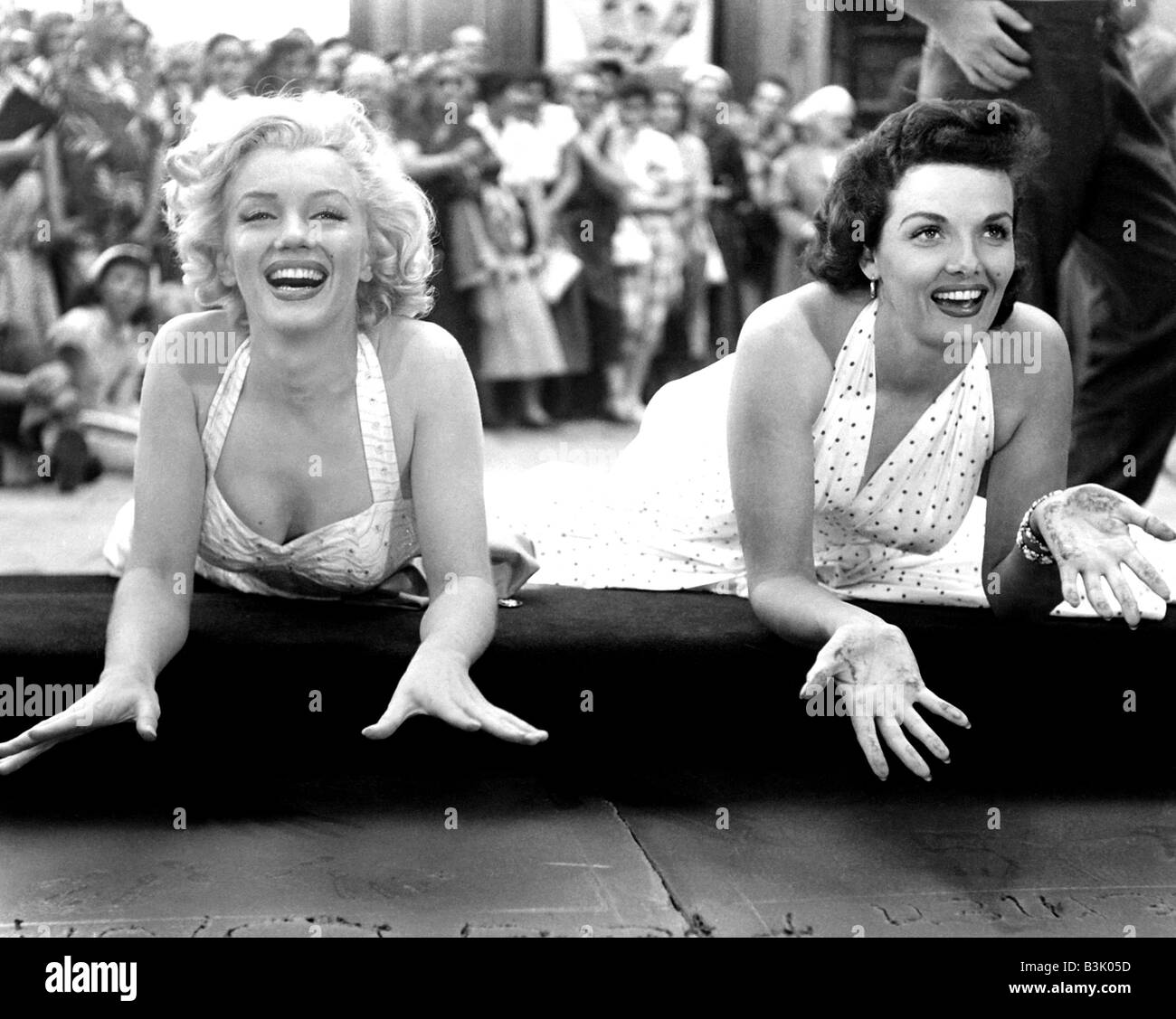 MARILYN MONROE at left and Jane Russell leave their handprints at Graumann's Chinese Theatre in Hollywood in 1953 Stock Photo