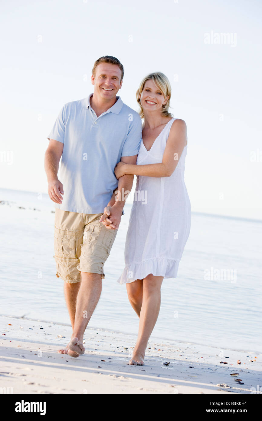 Couple at the beach holding hands and smiling Stock Photo