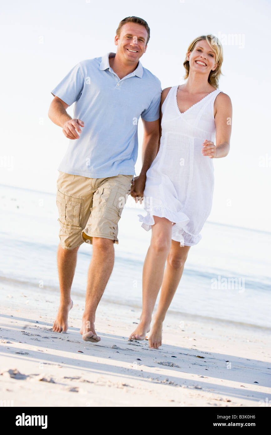 Couple at the beach holding hands and smiling Stock Photo