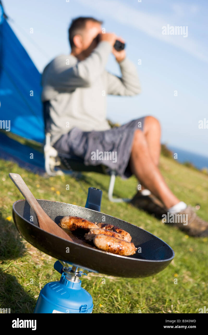 Man camping outdoors and cooking Stock Photo Alamy