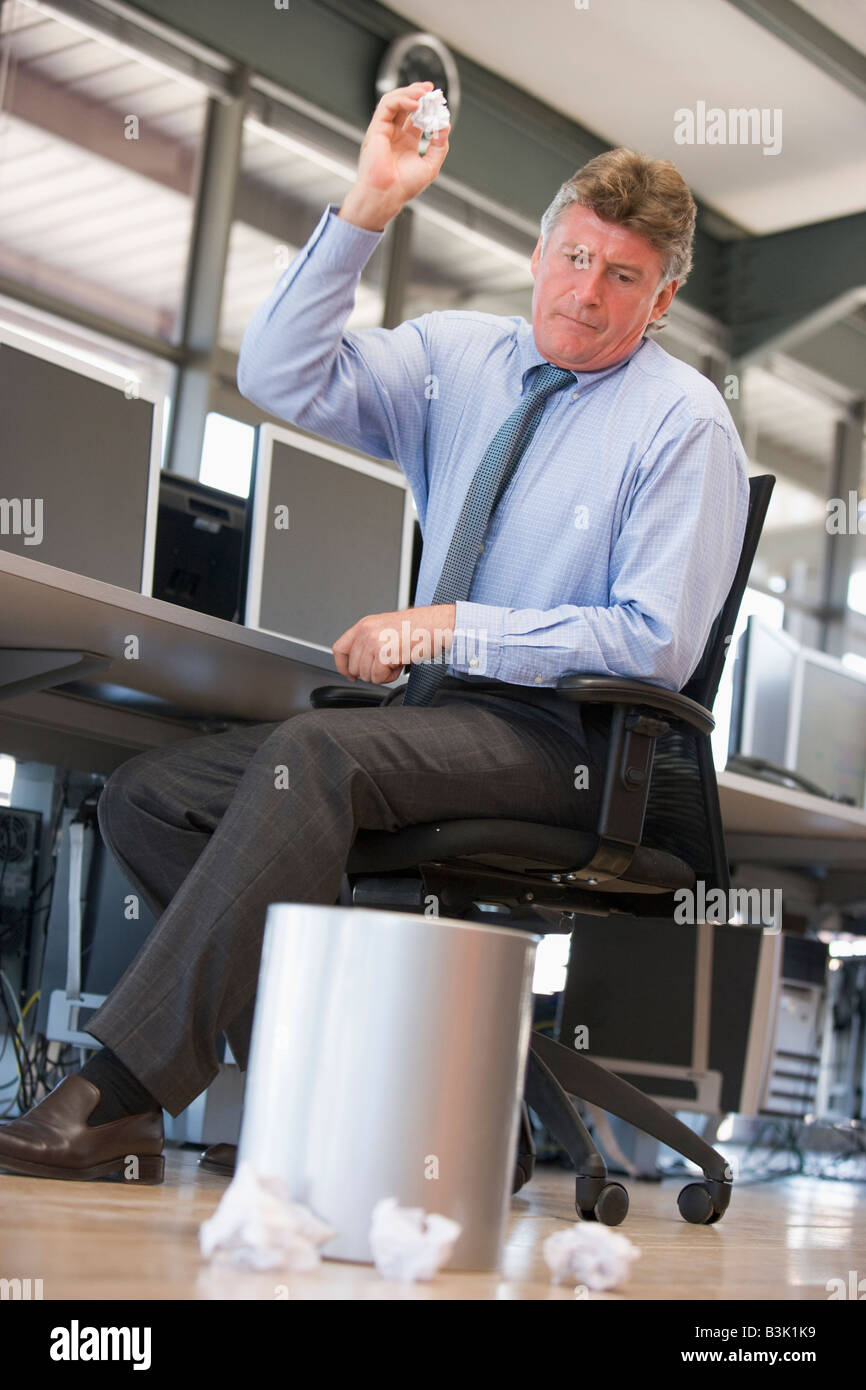 Businessman in office space throwing garbage in bin Stock Photo Alamy