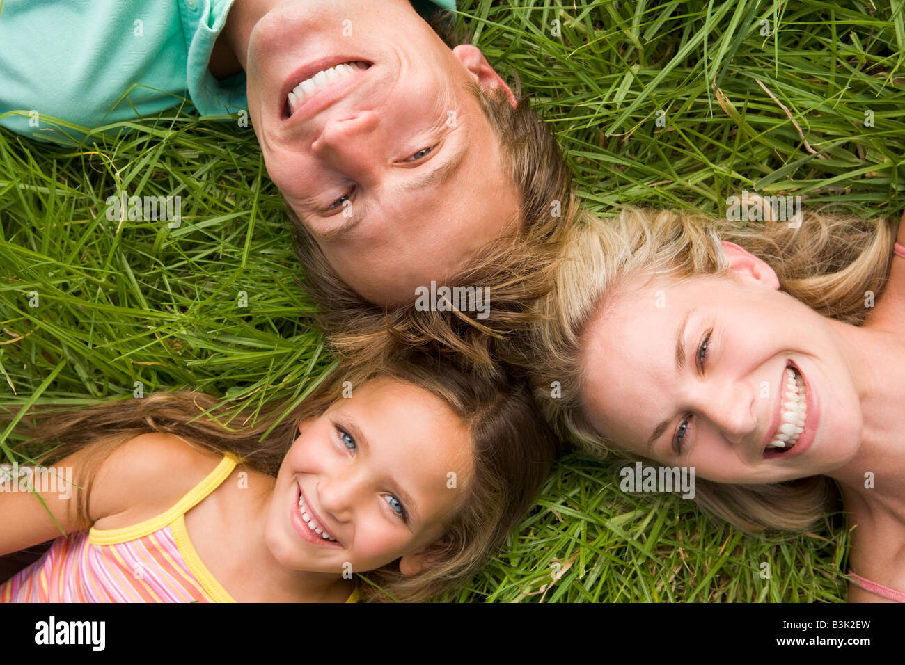 Family lying in grass smiling Stock Photo