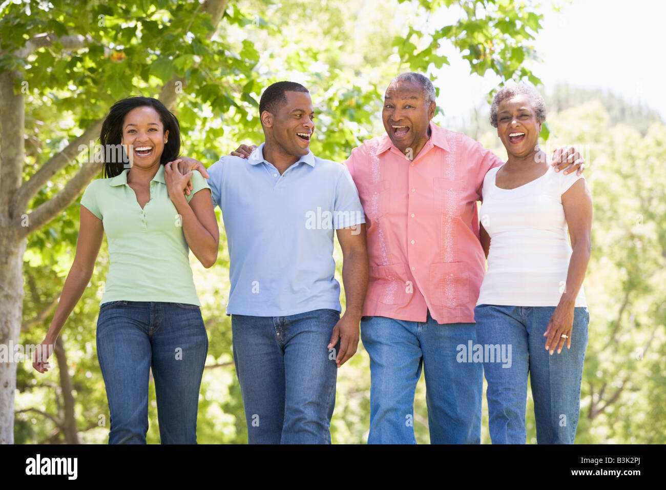 Two couples walking outdoors arm in arm smiling Stock Photo Alamy