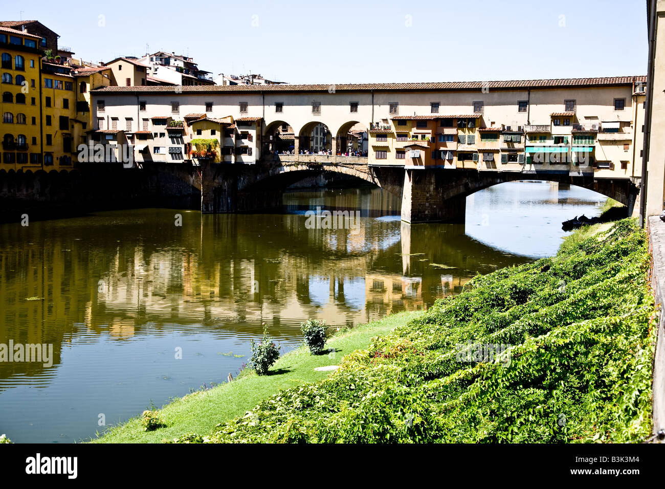 The Ponte Vecchio the ancient bridge that is a shopping street across the Arno Fiume river that flows through Tuscany Stock Photo