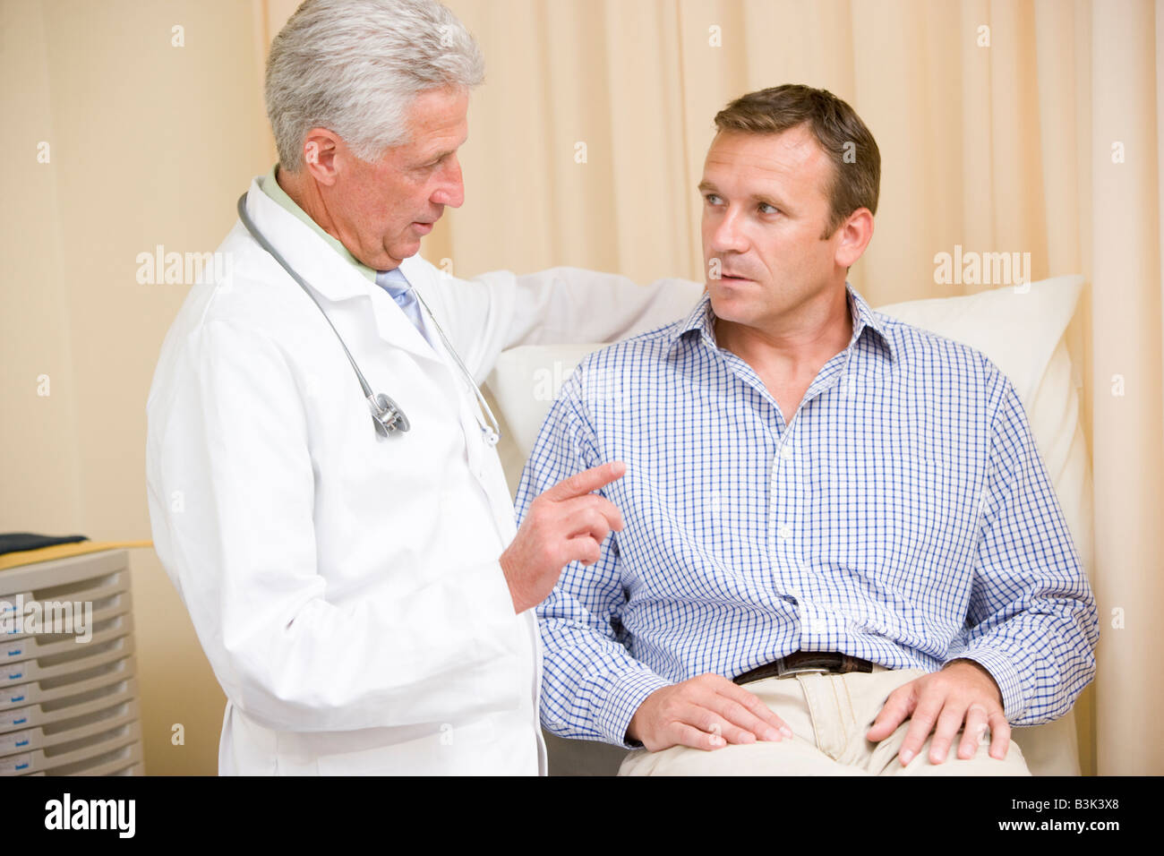 Doctor giving man checkup in exam room Stock Photo - Alamy