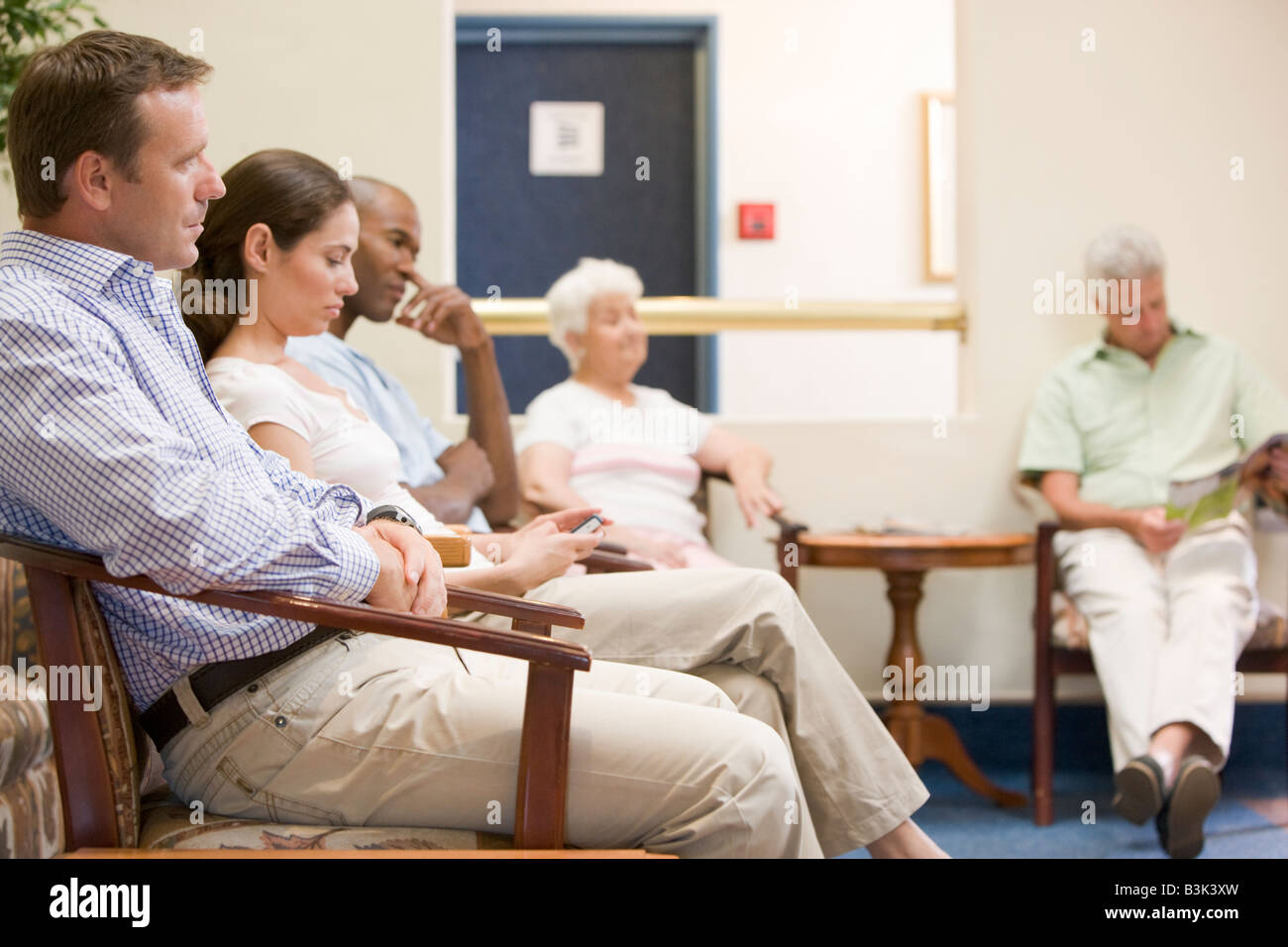 Five people waiting in waiting room Stock Photo