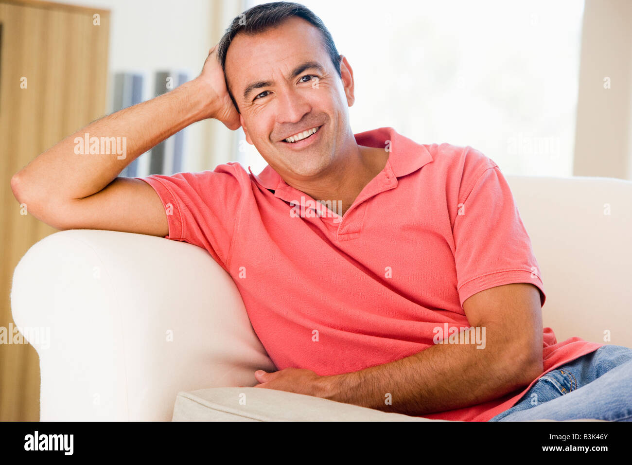 Man sitting in living room smiling Stock Photo