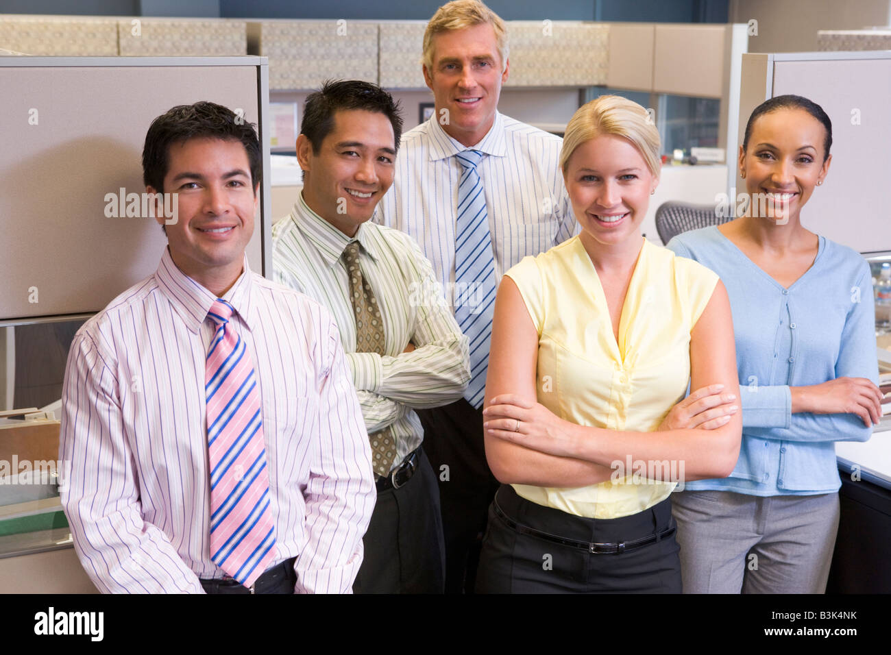 Business team standing in cubicle smiling Stock Photo - Alamy