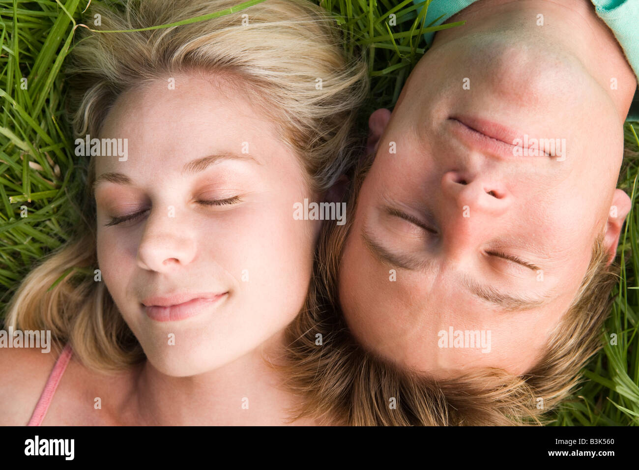 Couple lying in grass sleeping Stock Photo - Alamy