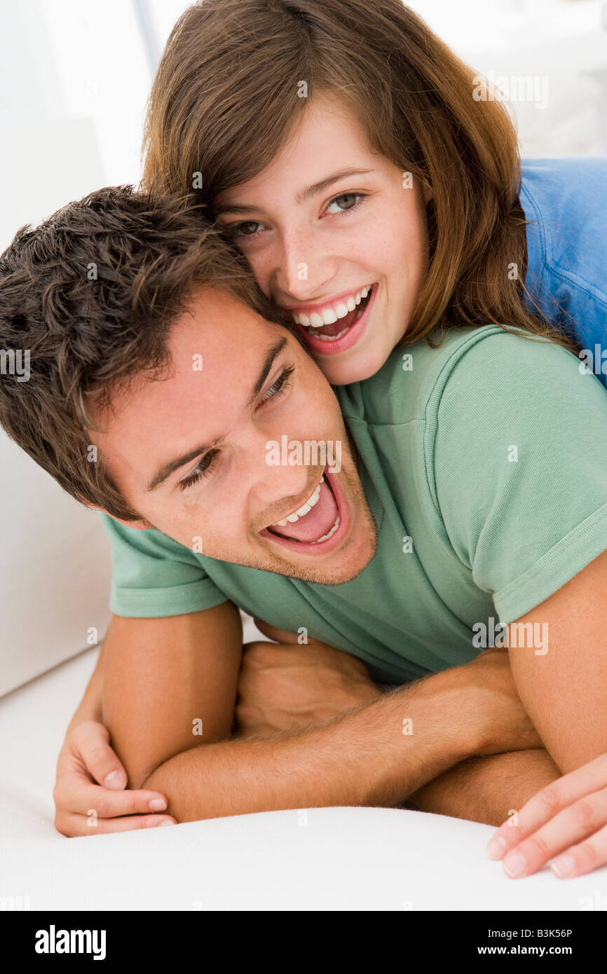 Couple in living room smiling Stock Photo - Alamy