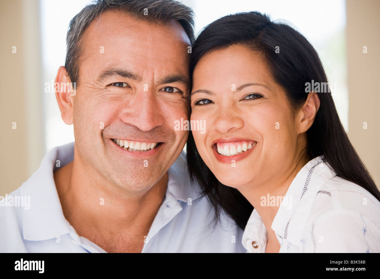 Couple in living room smiling Stock Photo - Alamy