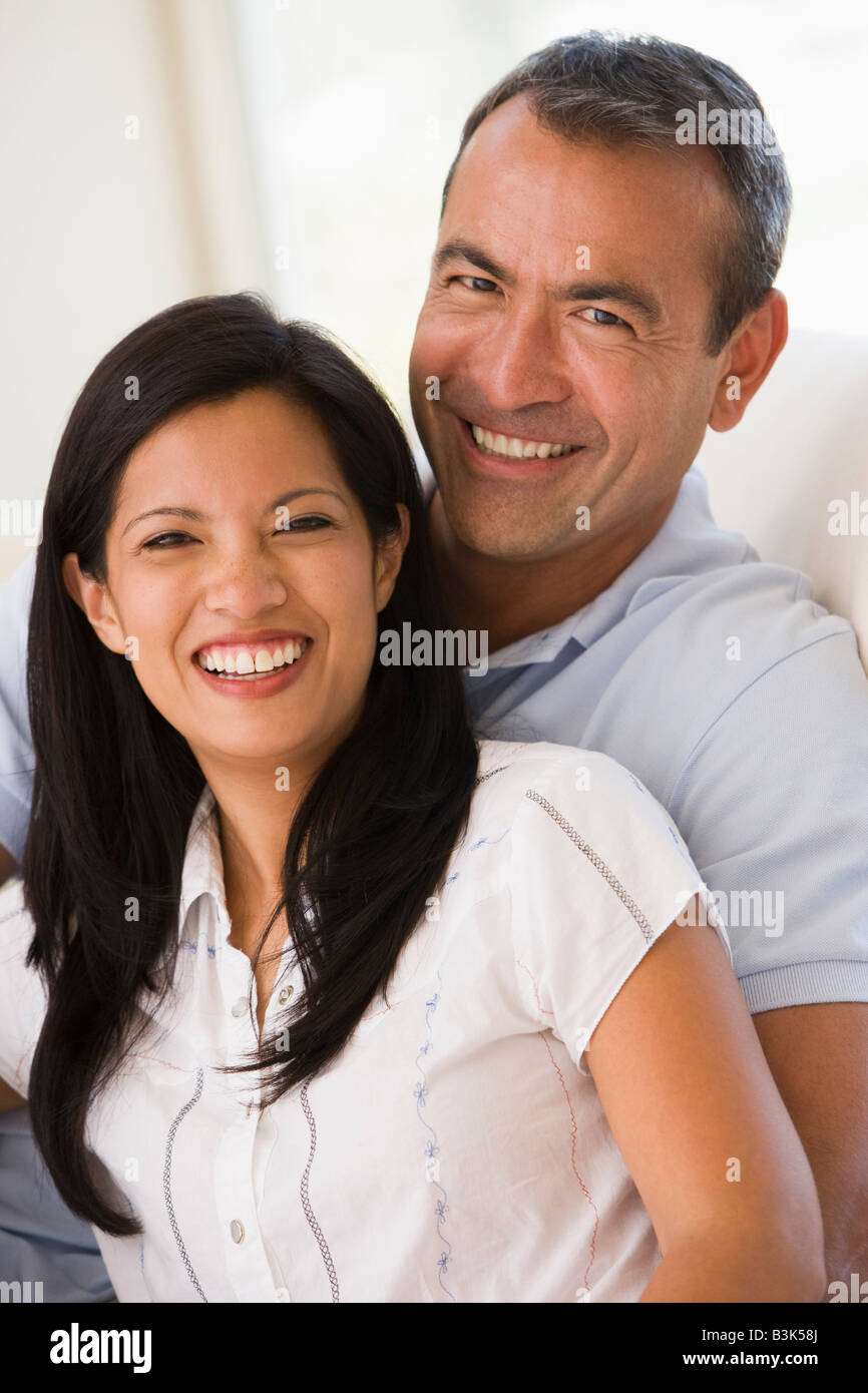 Couple in living room smiling Stock Photo - Alamy