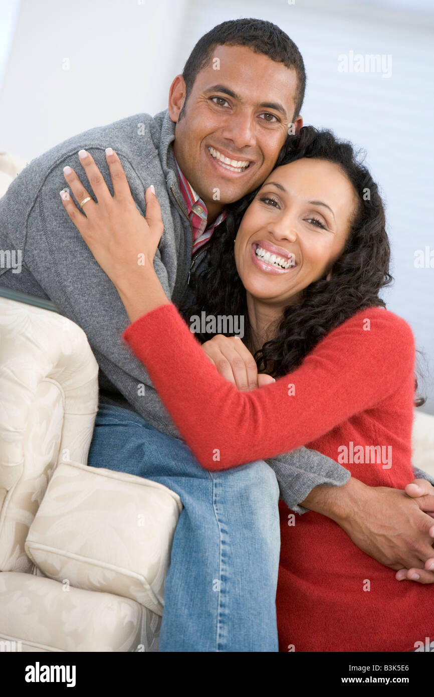 Couple in living room smiling Stock Photo - Alamy