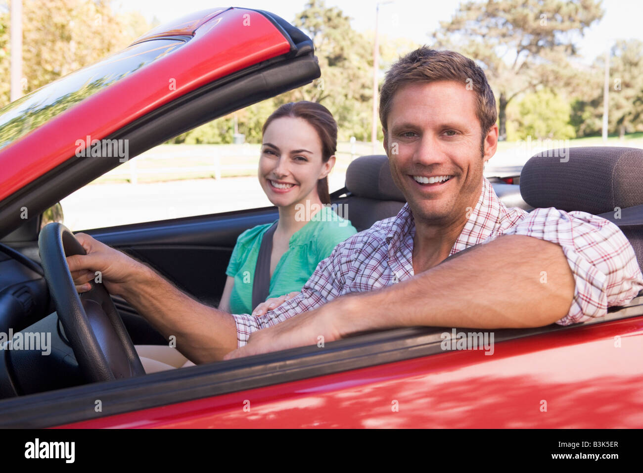 Couple in convertible car smiling Stock Photo - Alamy