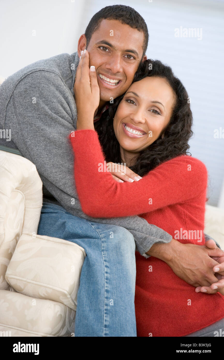 Couple in living room smiling Stock Photo - Alamy