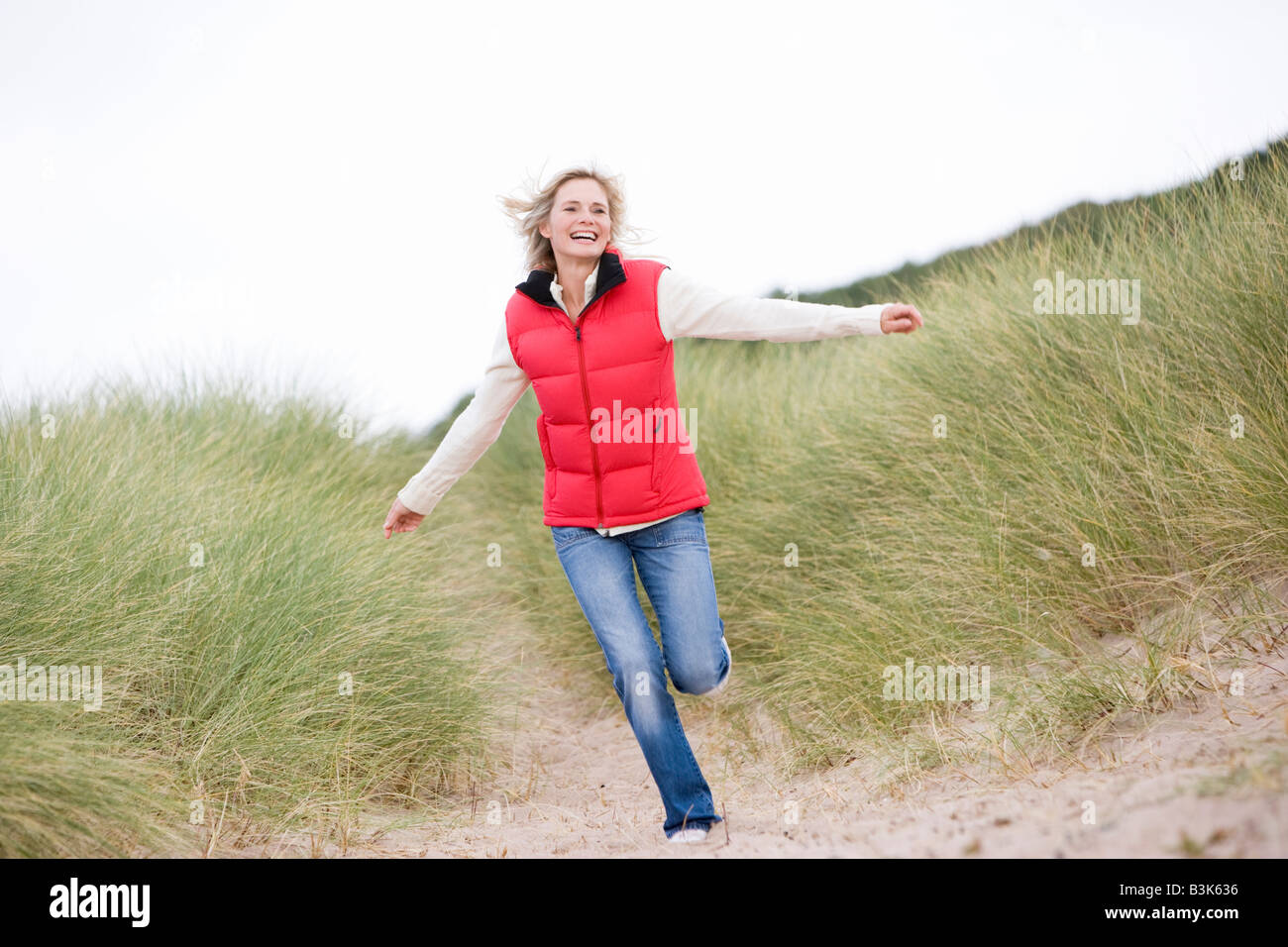 Woman running at beach smiling Stock Photo