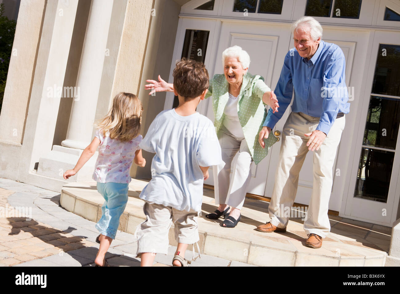 Grandparents welcoming grandchildren. Stock Photo