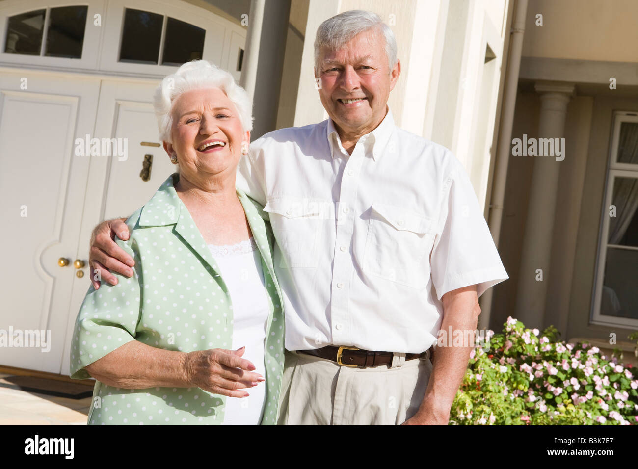 Senior couple standing outside their home Stock Photo - Alamy