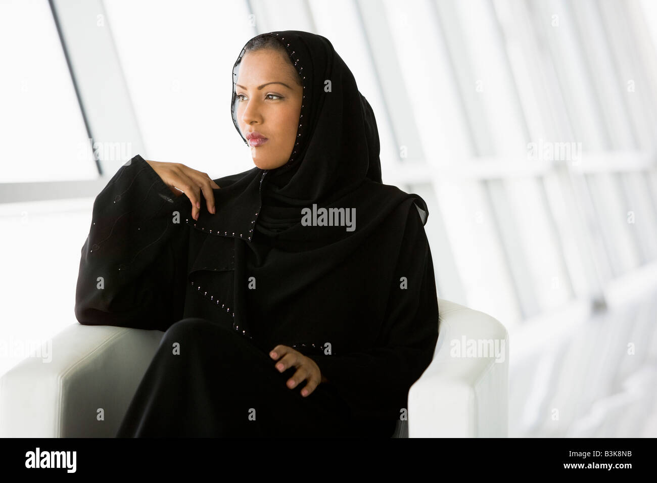 Woman sitting indoors (high key/selective focus) Stock Photo