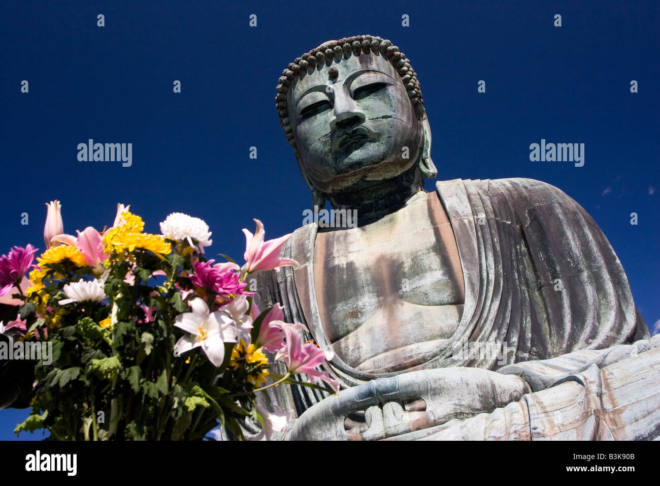 The Great Buddha statue behind flowers at the Kotoku in Temple in