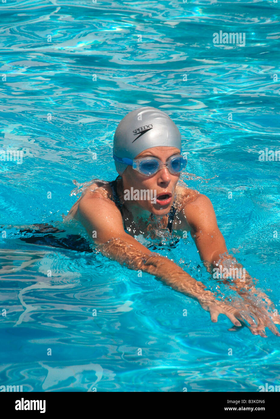 A woman swims in an  outdoor hotel swimming pool Stock Photo