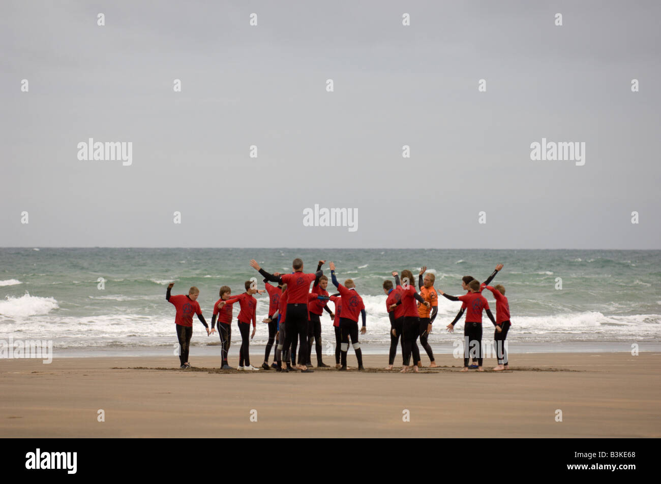 Surfing instructors get their pupils to warm up before going into the Atlantic Ocean at Widemouth Bay Cornwall Great Britain Eur Stock Photo
