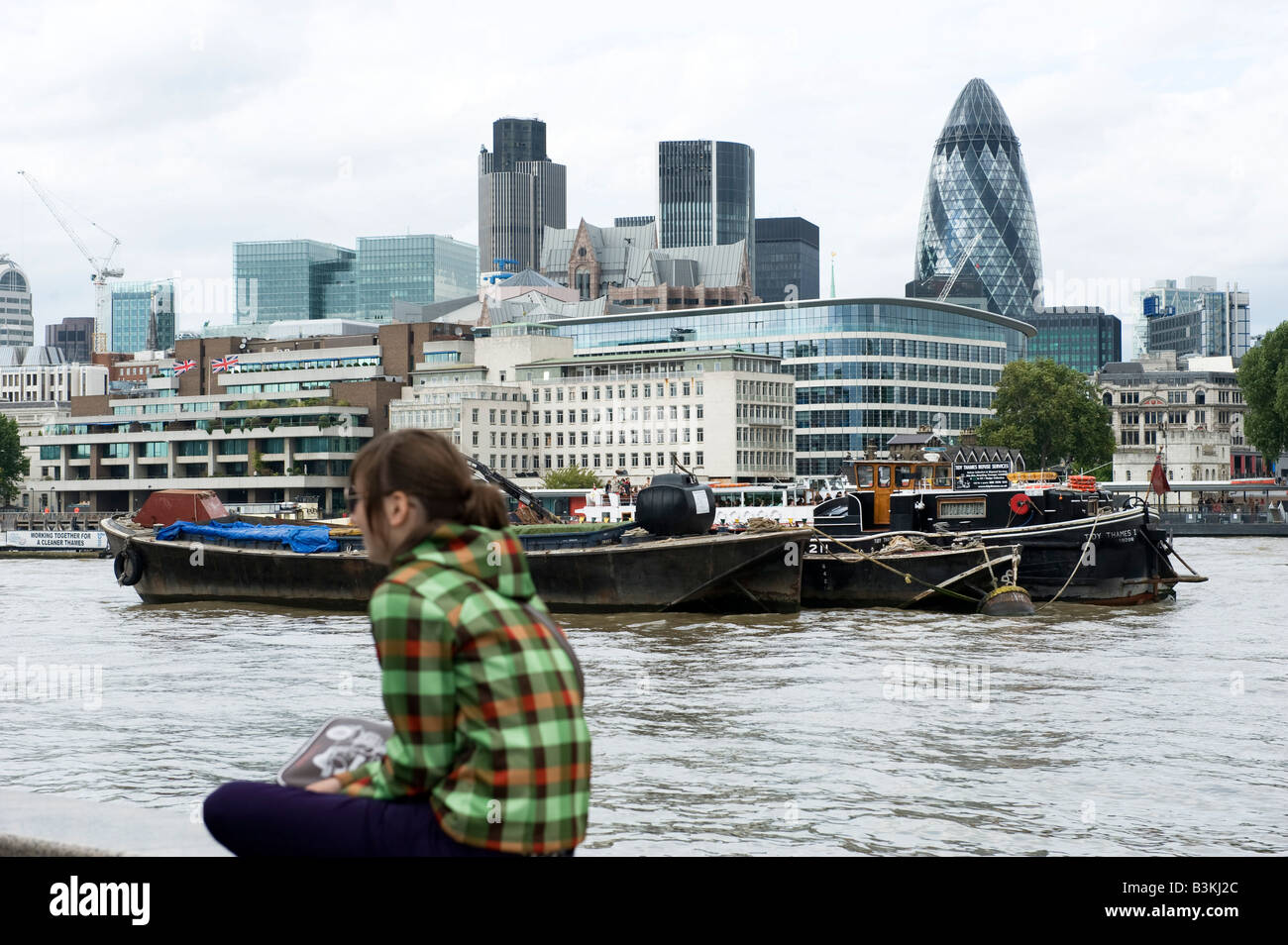 City of London outlined from south of the river as a boat goes by Stock Photo