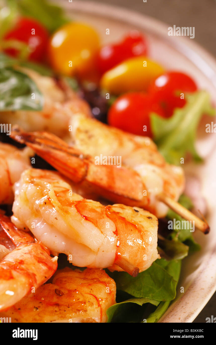 Skewers of cooked shrimp on dinner plate Stock Photo