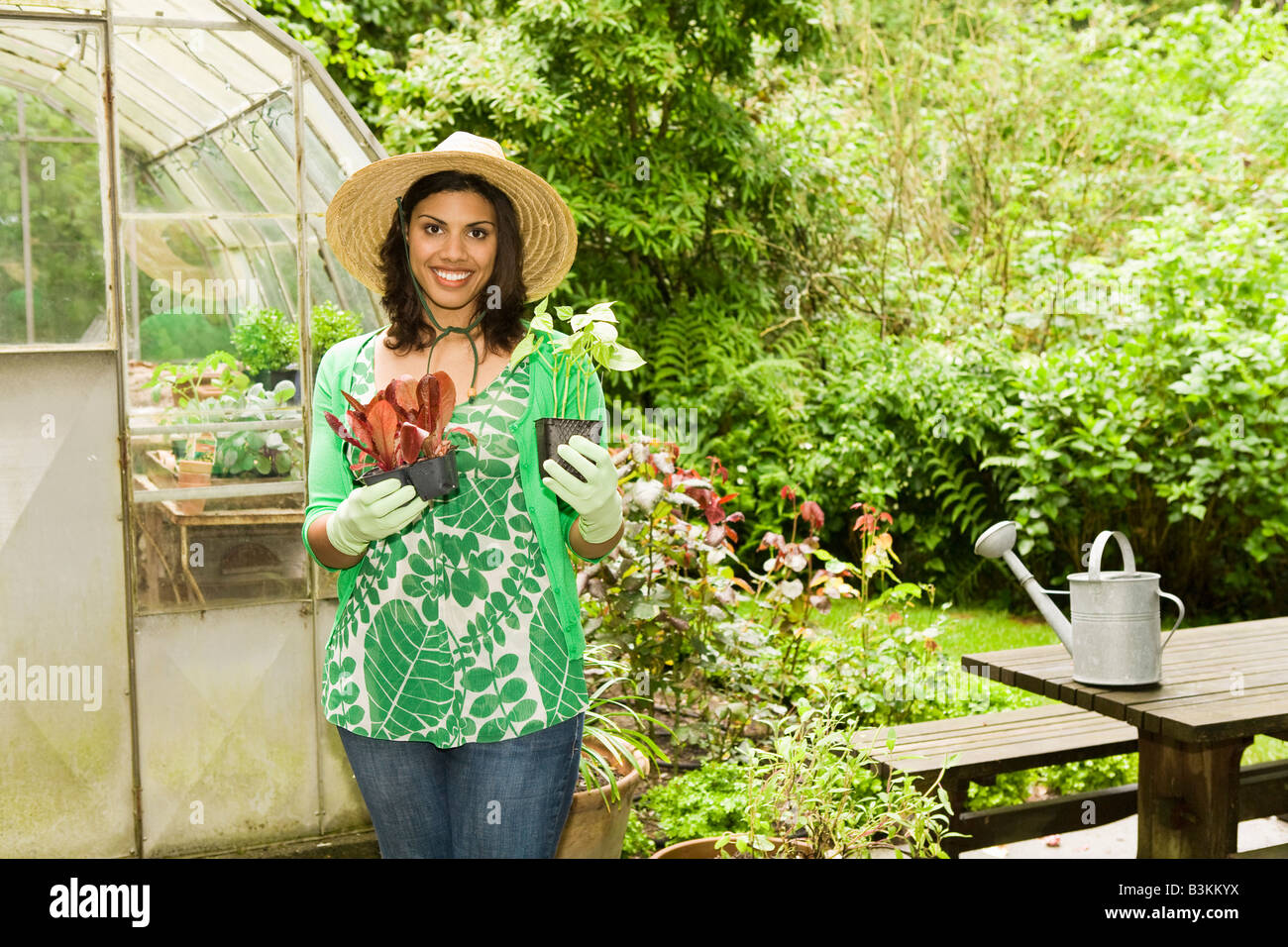 Woman holding plants in garden Stock Photo - Alamy