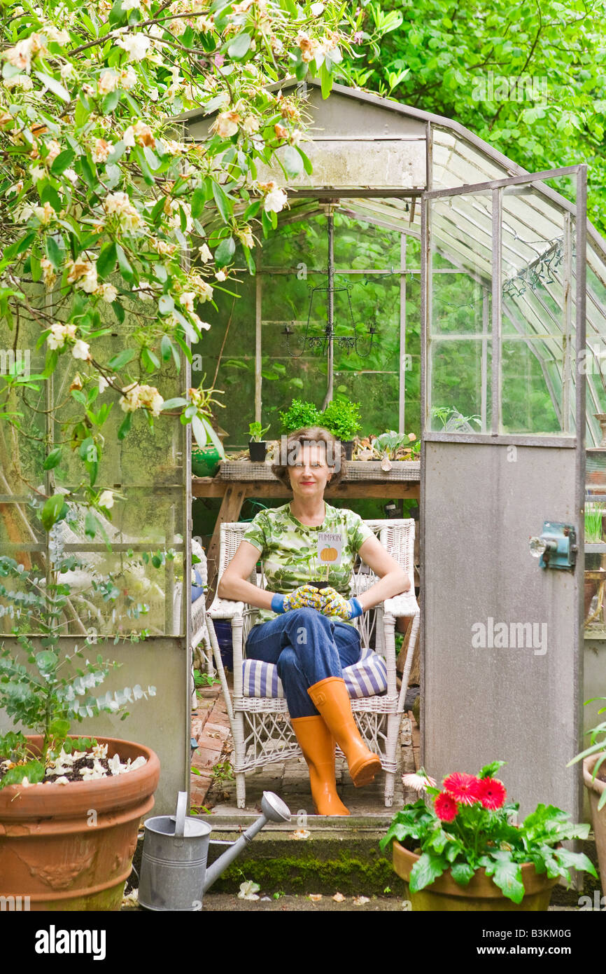 Woman sitting in backyard greenhouse Stock Photo - Alamy