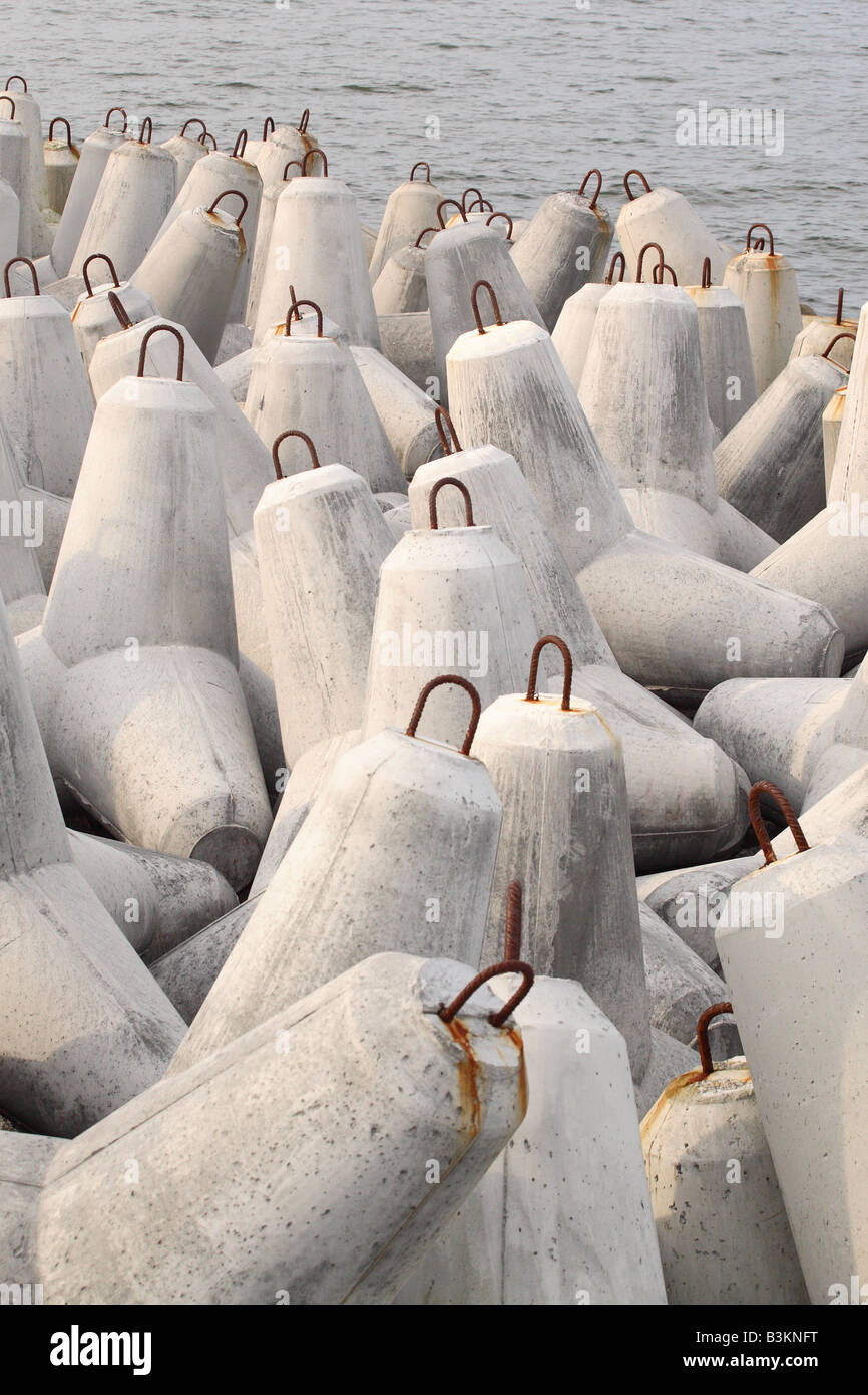 Concrete sea defence bollards to protect the coast from coastal erosion Stock Photo