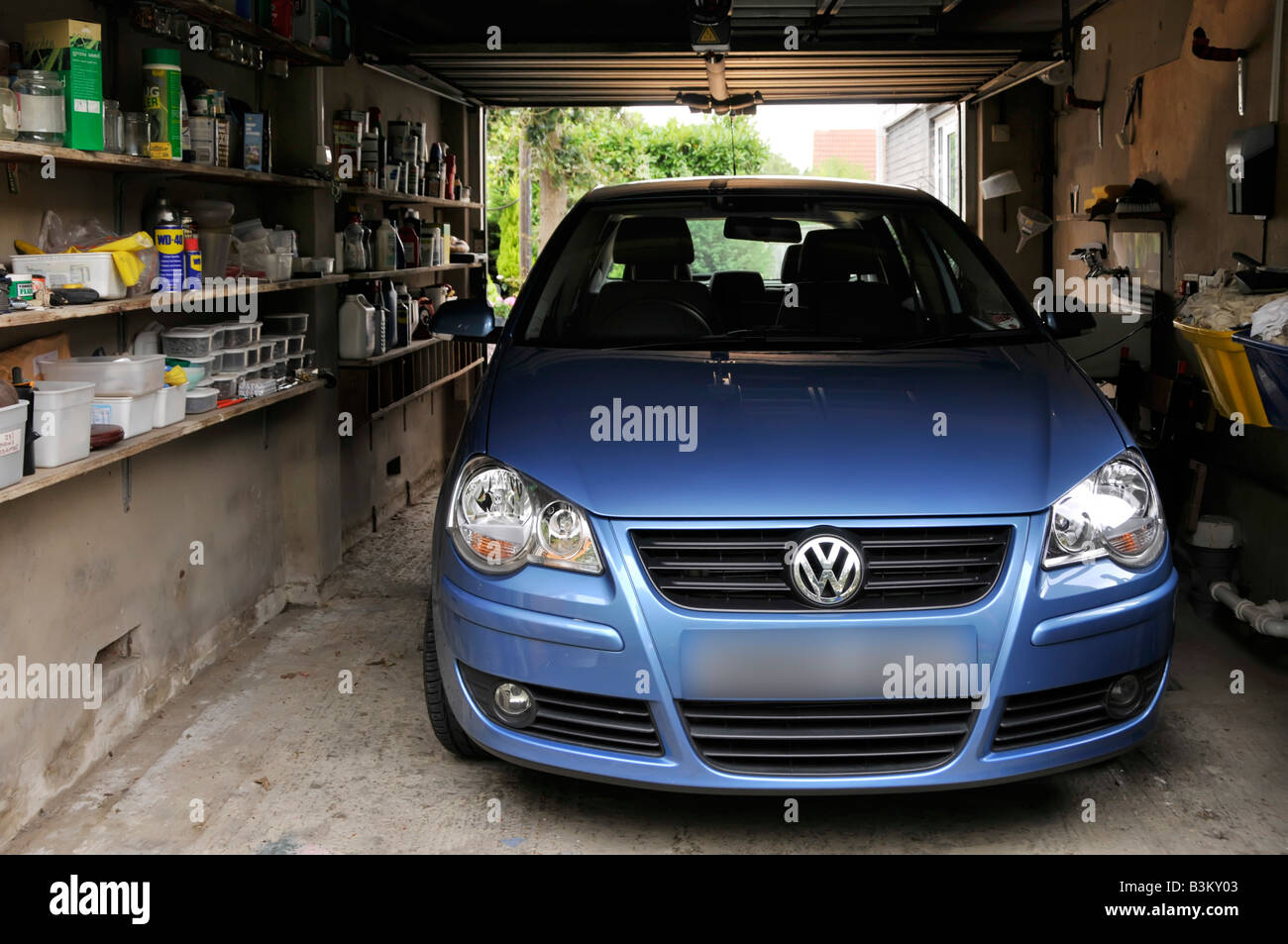 Volkswagen Polo car parked in attached house residential property garage shelving for storage of sundry household paraphernalia & tools England UK Stock Photo - Alamy