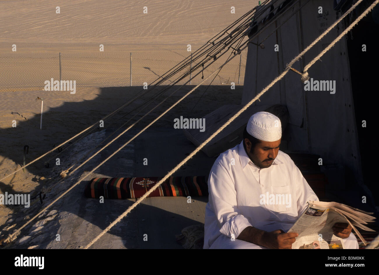 Qatar, Middle East, Asia, arab man reading a newspaper near a tend in ...