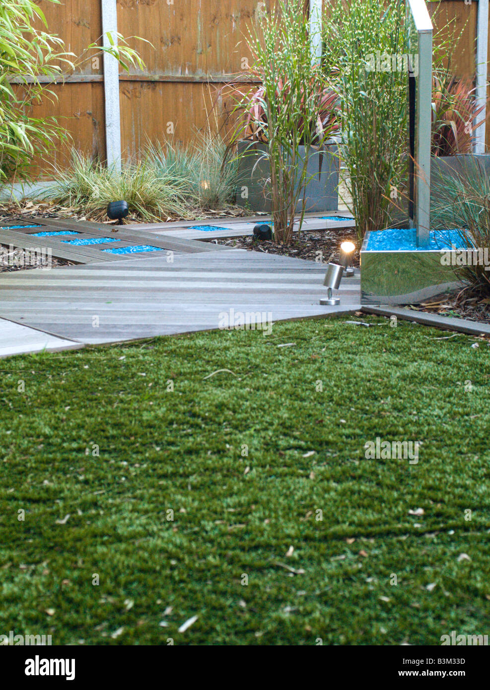 modern landscaped garden with water feature and astro-turf lawn and decking Stock Photo