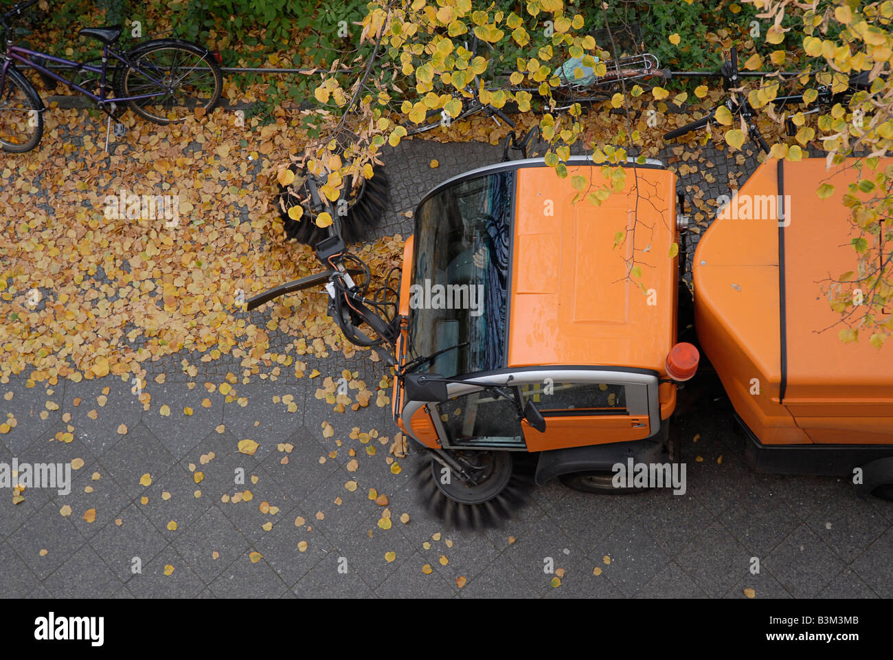 A road sweeper clearing leaves from the street Stock Photo - Alamy
